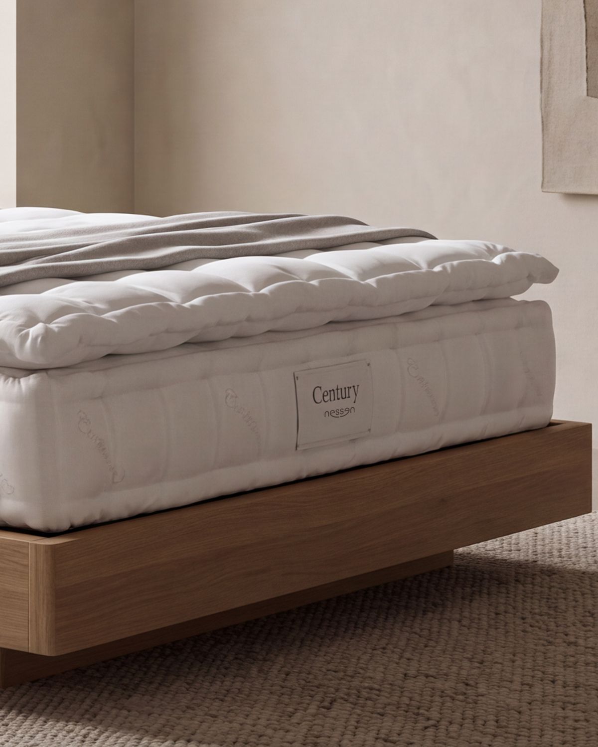Close-up of the Nessen Century mattress: quilted topper, side panel and label